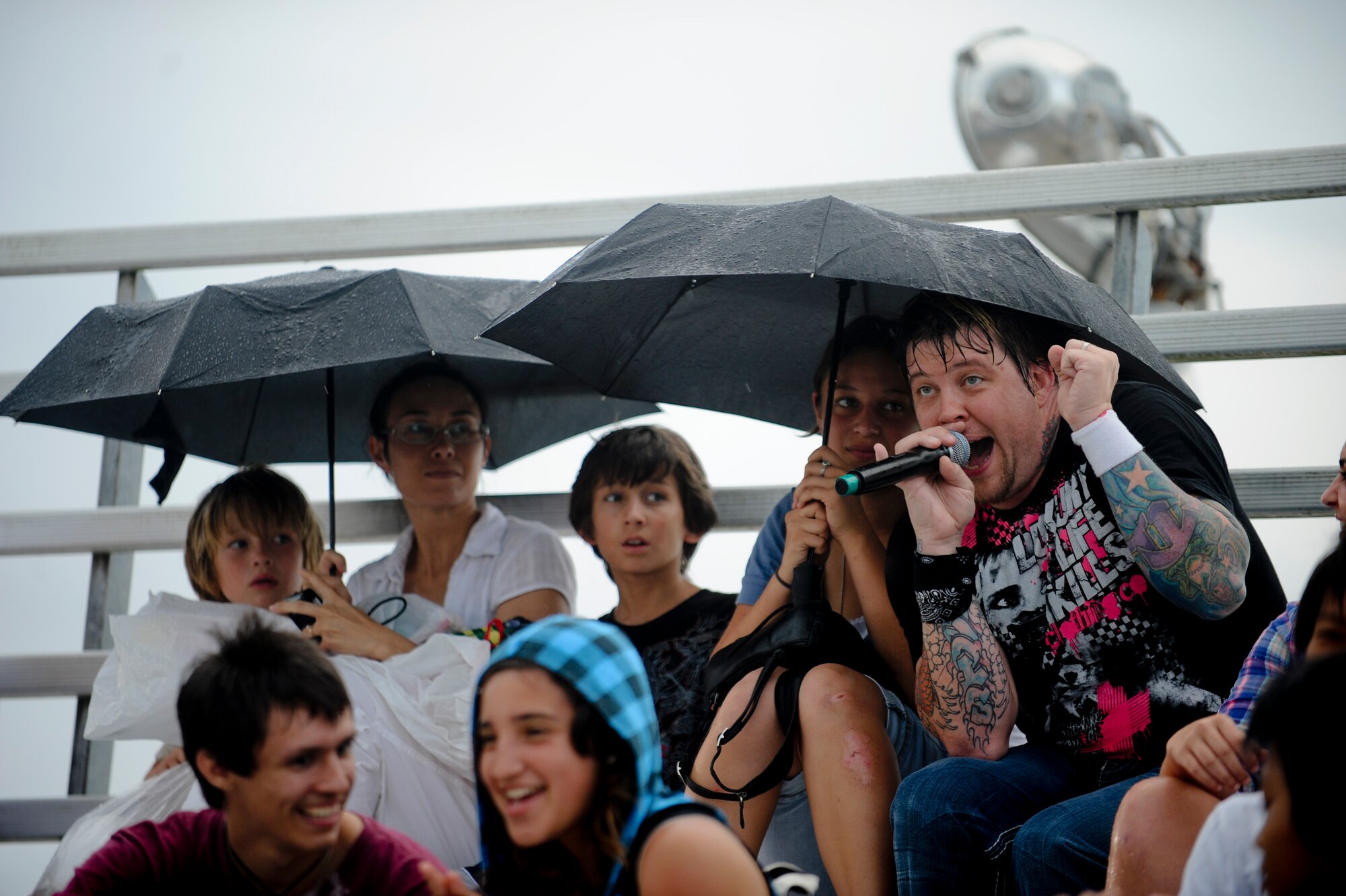 Lead Singer Paul McCoy for 12 Stones sings in the rain with the crowd at AmericaFest July 2. AmericaFest is a chance to celebrate Independence Day and share the celebration with our Japanese counterparts. Food, games and musical entertainment were also provided. (U.S.  Air Force Photo/Staff Sgt. Jonathan Steffen)