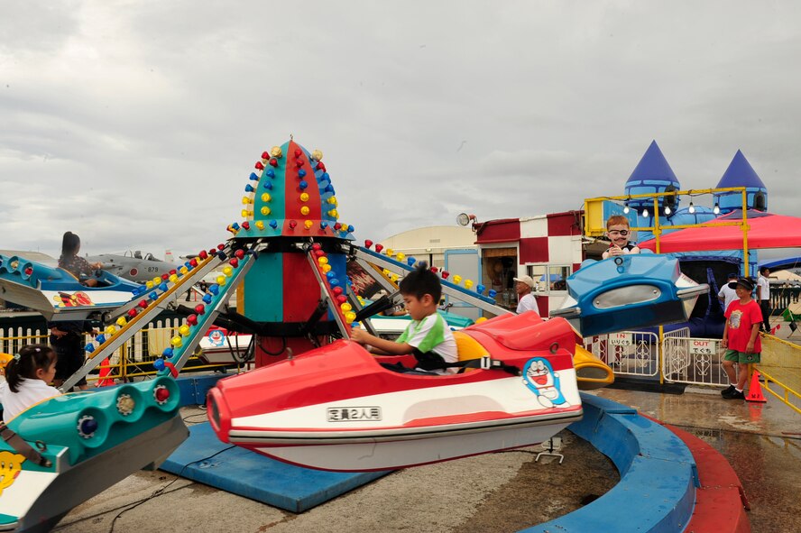 Children from the local community find amusement on the space ship ride during America Fest 2011 at Kadena Air Base, June 2. Team Kadena and local personnel will enjoy local cuisine, entertainment, and opportunity to see different aircraft from the base. (U.S. Air Force photo/ Staff Sgt. Lakisha A.Croley)