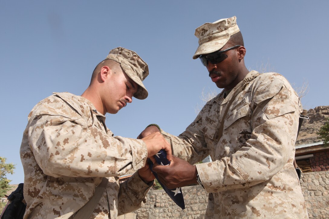 Cpl. Israel W. Owens, a field artillery radar operator with 2nd Battalion, 12th Marine Regiment, folds the United States national ensign. Owens performs various duties as the Sergeant of the Guard for 2/12, supporting his platoon as it provides local security for the FOB. (Official U.S. Marine Corps Photo by Sgt. Earnest J. Barnes)::r::::n::::r::::n::::r::::n::