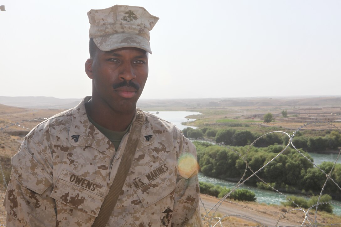 Cpl. Israel W. Owens, a field artillery radar operator with 2nd Battalion, 12th Marine Regiment, poses for a photograph with 2/12’s area of operations canvassing the background. Owens recently received a meritorious promotion to his current rank through his initiative and determination to excel. (Official U.S. Marine Corps Photo by Sgt. Earnest J. Barnes)::r::::n::::r::::n::::r::::n::