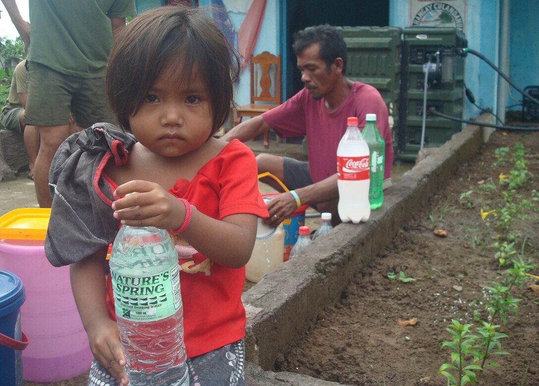 A little girl holds onto a bottle of purified water she received, July 4, from the water distribution area in her native village of Culandanum, Palaw-an. A cholera outbreak was declared, April 1, in Culandanum after at least 11 people died due to severe diarrhea, vomiting and dehydration believed to be caused by contaminated water.