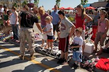 Staff Sgt. Timothy Anderson, 31, from Fall Creek, Wis., hands out some Marine Corps memorabilia while waiting for the Forest Lake Fourth of July Annual Parade to continue. Anderson, a recruiter out of the Coon Rapids, Minn., office, drove a branded H3 and, with the help of a few aspiring Marines, handed out more than 1,500 stickers and pencils to children along the parade route. For additional imagery from the event, visit www.facebook.com/rstwincities.
