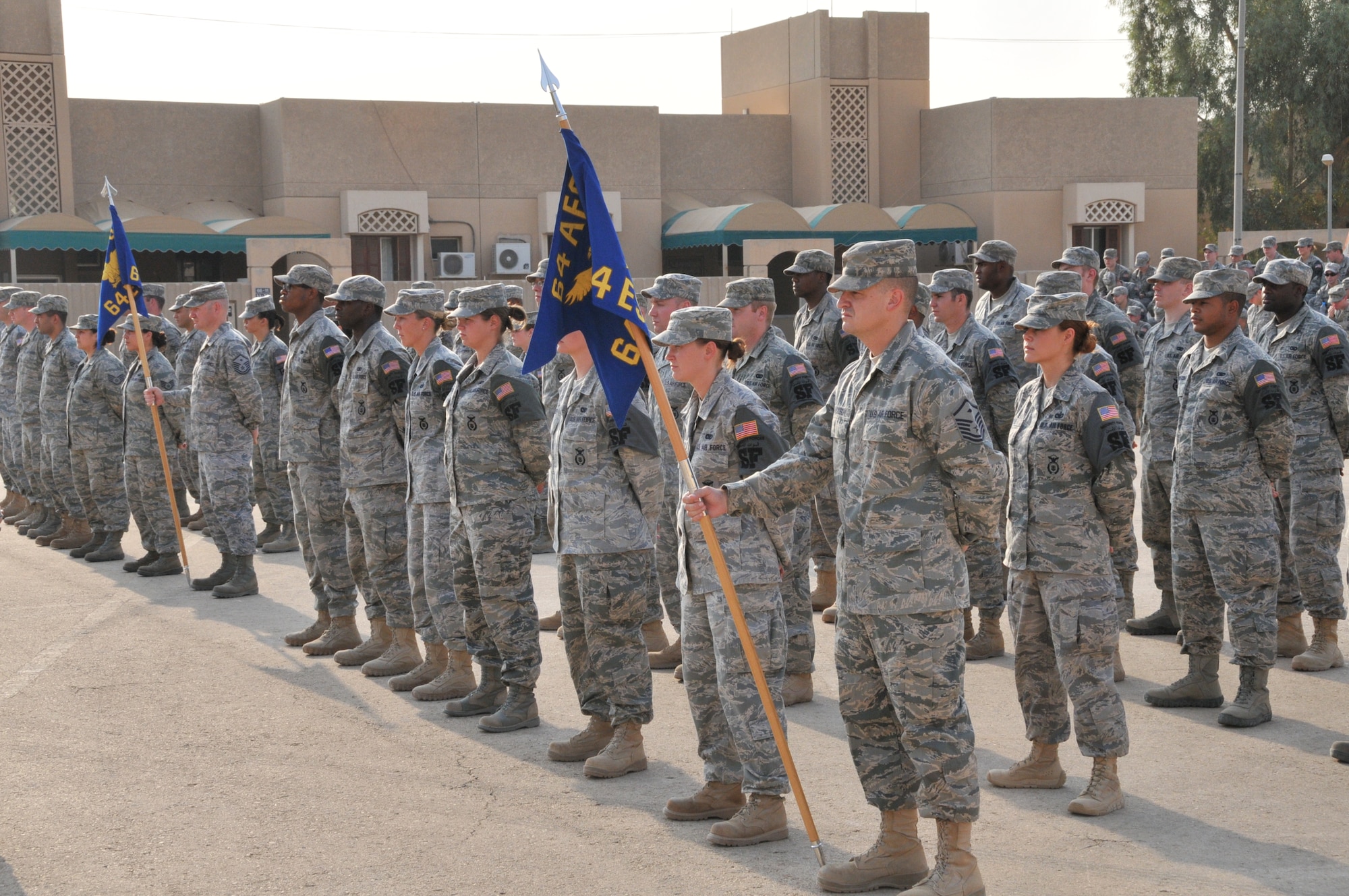 Members of the 64th Air Expeditionary Group stand in formation during the 64 AEG change of command ceremony, June 29, in Southwest Asia. Col. Shannon Jurrens assumed command of the group from Col. Gary Nelson. The 379th Air Expeditionary Wing commander, Col. Giovanni K. Tuck, presided at the ceremony. The 64 AEG is a geographically separated unit of the 379 AEW, and provides security and base support to an undisclosed location in the Middle East.  (U.S. Air Force photo/Master Sgt. Mike Hammond)