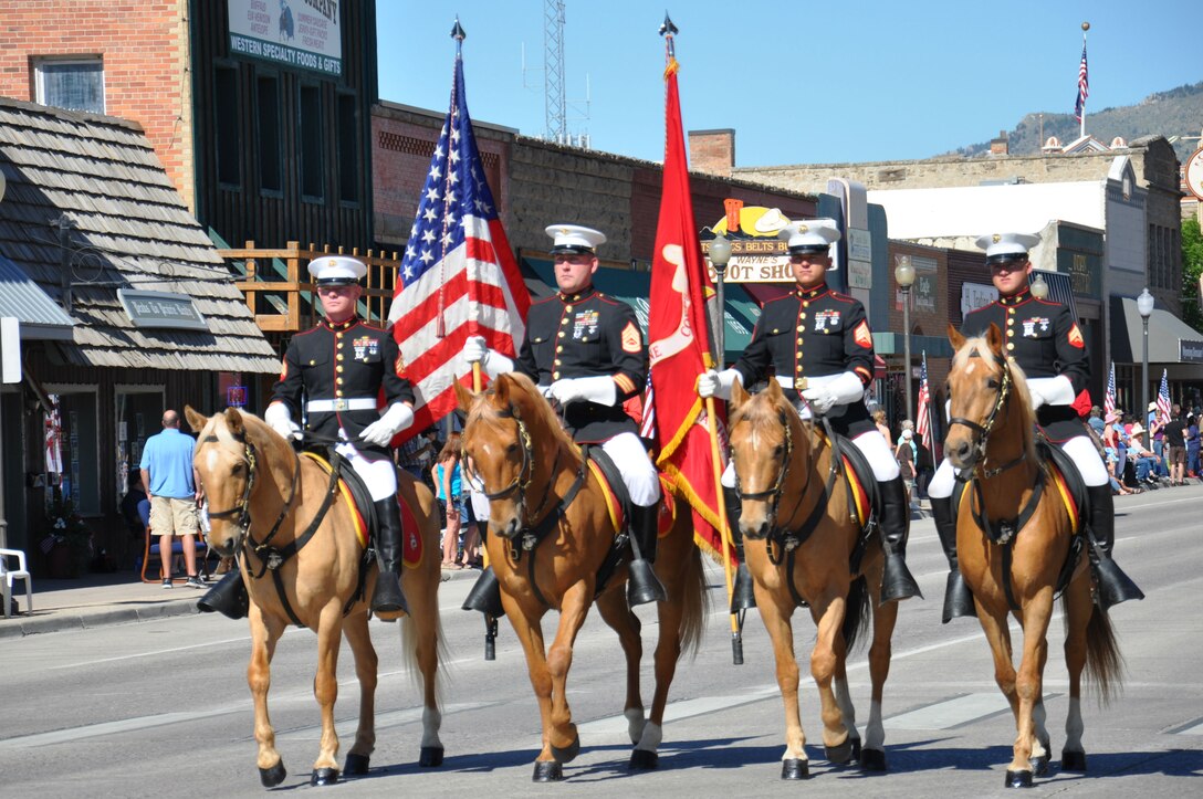 (From right) Cpl. Anthony Villalobos, Sgt. Darren Cole , Gunnery Sgt. Michael Bate, staff noncommissioned officer in charge, Mounted Color Guard and Sgt. Jacey Marks ride in the parade to kick off the Cody, Wyo.,  Stampede Rodeo July 4. Though a corporal, Villalobos has served in the unit longer than the other three members and acts as their mentor at times.