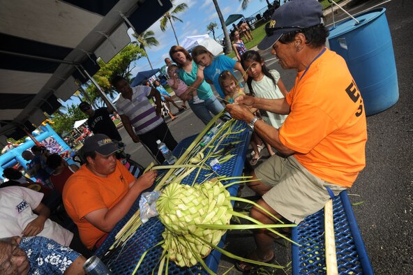 MWR staff show children how to weave baskets and hats at Hickam Harbor on July 4. The festivities, sponsored by MWR, included bouncy houses,  food vendors and a free concert by the Plain White T's.  Hundreds of families and military members camped at the harbor the night before and stayed to enjoy the brilliant display of Fourth of July fireworks that evening. (U.S. Air Force photo/Senior Airman Lauren Main)