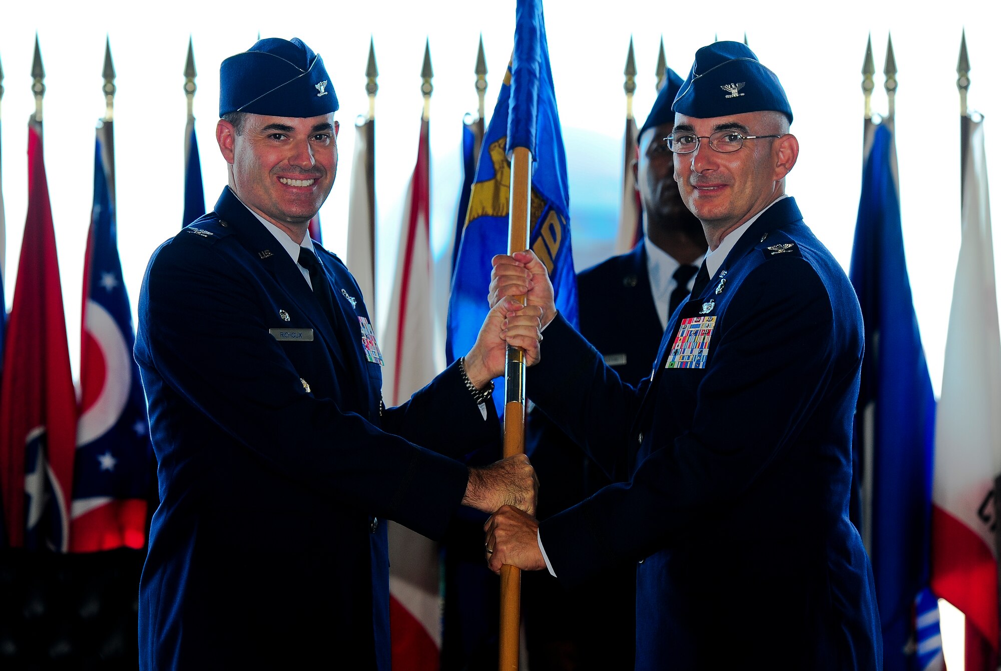 Col. Lenny Richoux, 6th Air Mobility Wing commander, passes the guideon to Col. Robert Rocco as he accepts command of the 6th Medical Group during a Change of Command Ceremony July 5, 2011 in Hangar 3 at MacDill Air Force Base, Fla. (U.S. Air Force photo by Airman Basic David Tracy)