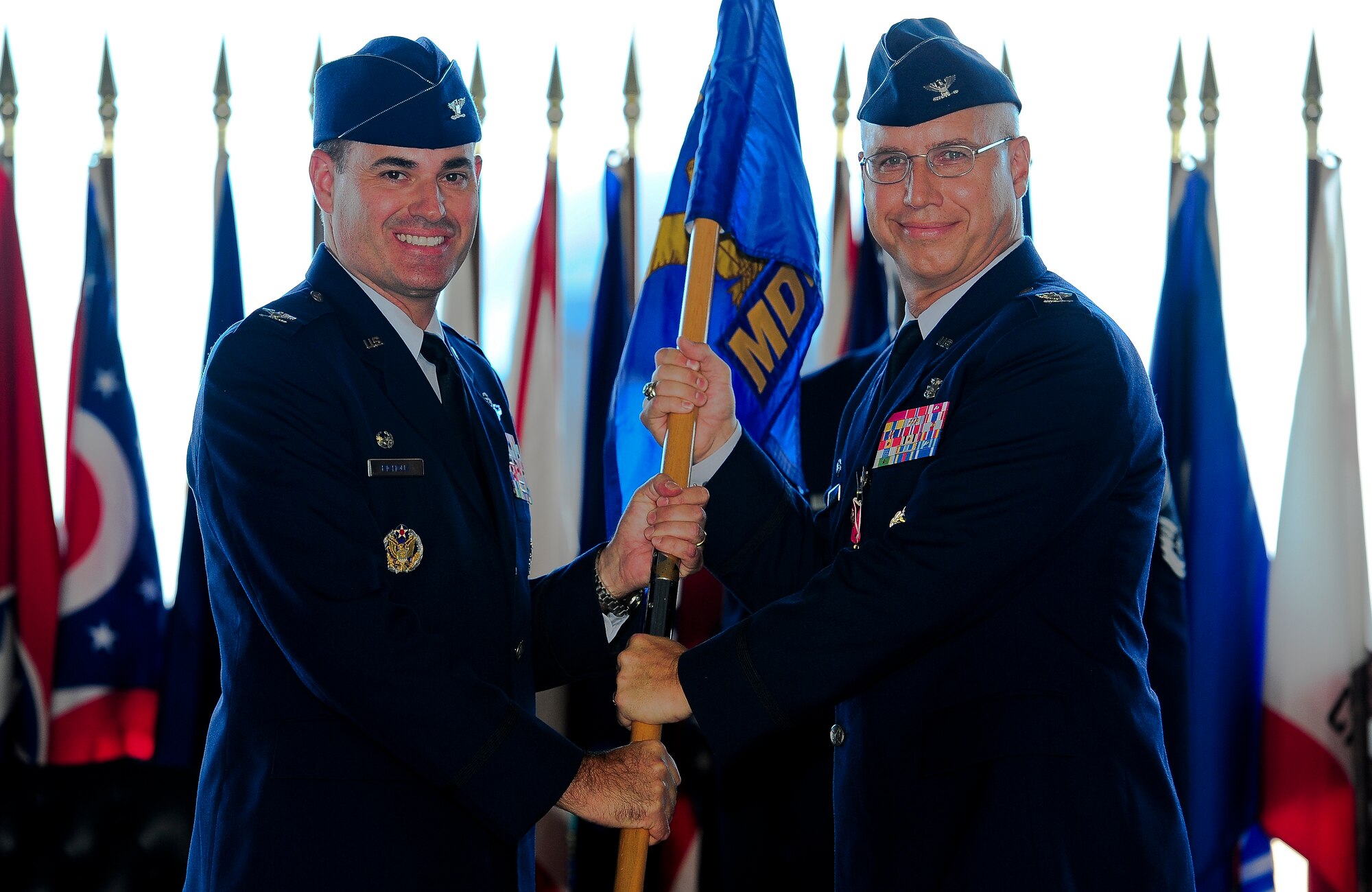 Col. Lenny Richoux, 6th Air Mobility Wing commander, accepts the guideon from Col. Dennis Beatty, former  6th Medical Group commander, during a Change of Command Ceremony, July 5, 2011, in Hangar 3 at MacDill Air Force Base, Fla. (U.S. Air Force photo by Airman Basic David Tracy)