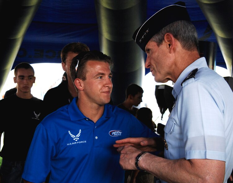 A.J. Allmendinger, NASCAR driver for the Air Force-sponsored #43 car, listens to Air Force Chief of Staff Gen. Norton Schwartz July 2, 2011, at the Coke Zero 400 in Daytona Beach, Fla. Schwartz thanked him for taking time to support recruiting efforts and representing the Air Force while he drove. Allmendinger ended up placing 10th in the race. (U.S. Air Force photo by Airman 1st Class Brigitte N. Brantley/Released)
