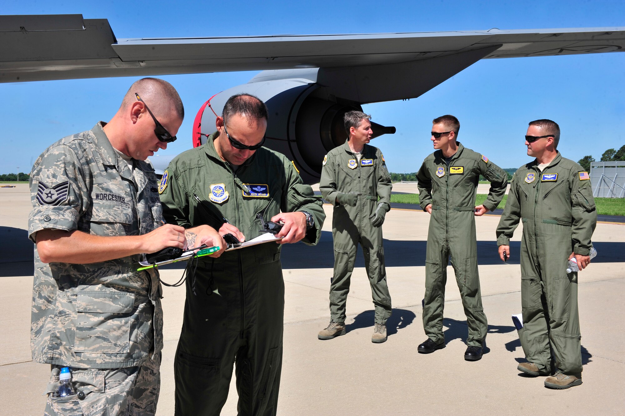 Tech. Sgt Matthew Worcester and Master Sgt. Kevin Valasek fill out an inspection sheet after a KC-135 egress scenario on Scott AFB June 28, 2011. Sergeant Worcester is an evaluator from the Test and Evaluations Squadron at Dover AFB, Del., and Sergeant Valasek is an evaluator from the AMC TES at Scott AFB. The AMC directed test was used to determine the quantity of passengers one passenger monitor can safely egress, or evacuate, from an aircraft in 90 seconds. (U.S. Air Force photo/ Staff Sgt. Stephenie Wade)