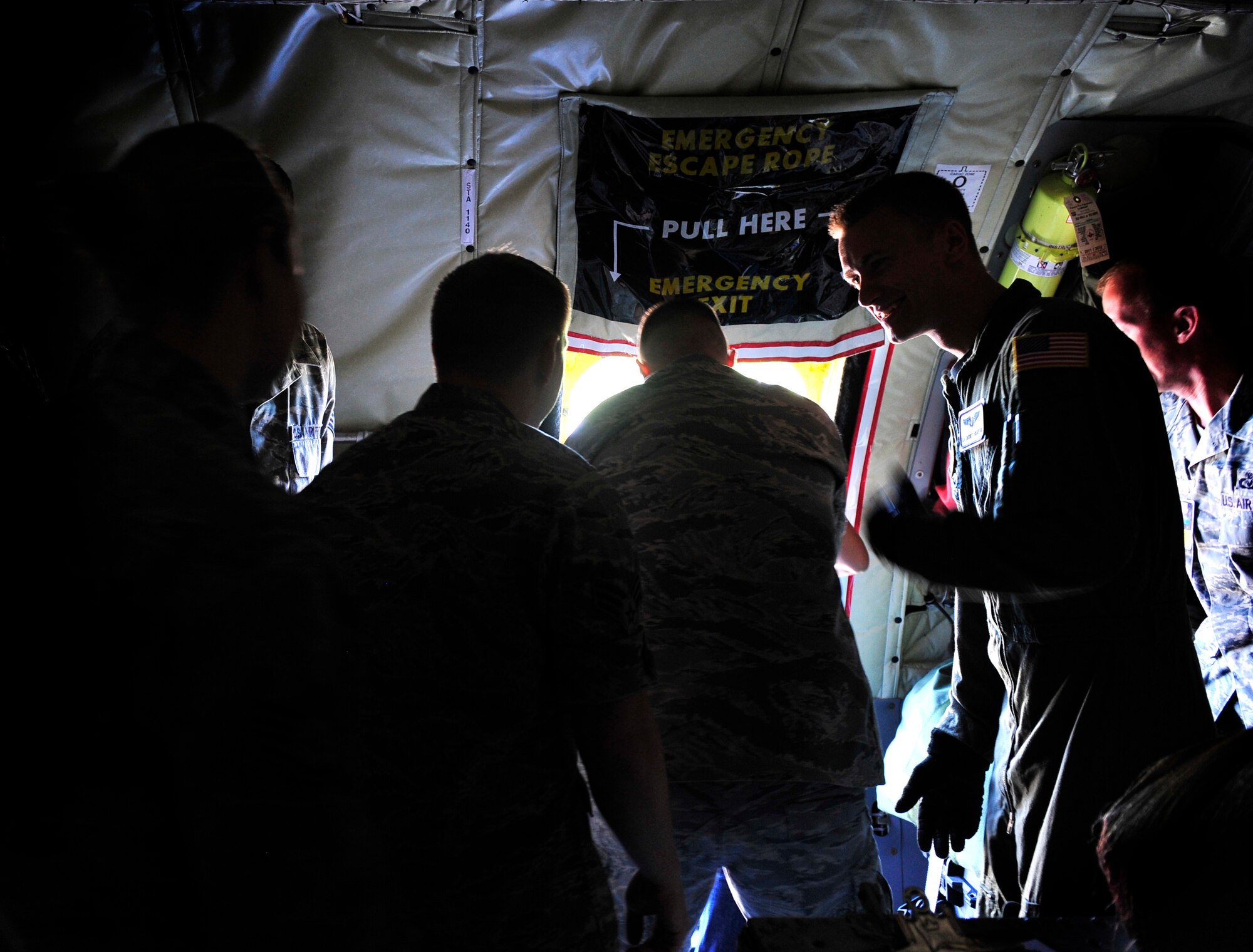 Airman 1st Class Jarrett Crawford gives evacuation directions to passengers on a KC-135 during an egress scenario on Scott AFB June 28, 2011. Airman Crawford is a boom operator apprentice at the 906th Air Refueling Squadron. The AMC directed test was used to determine the quantity of passengers one passenger monitor can safely egress, or evacuate, from an aircraft in 90 seconds. (U.S. Air Force photo/ Staff Sgt. Stephenie Wade)