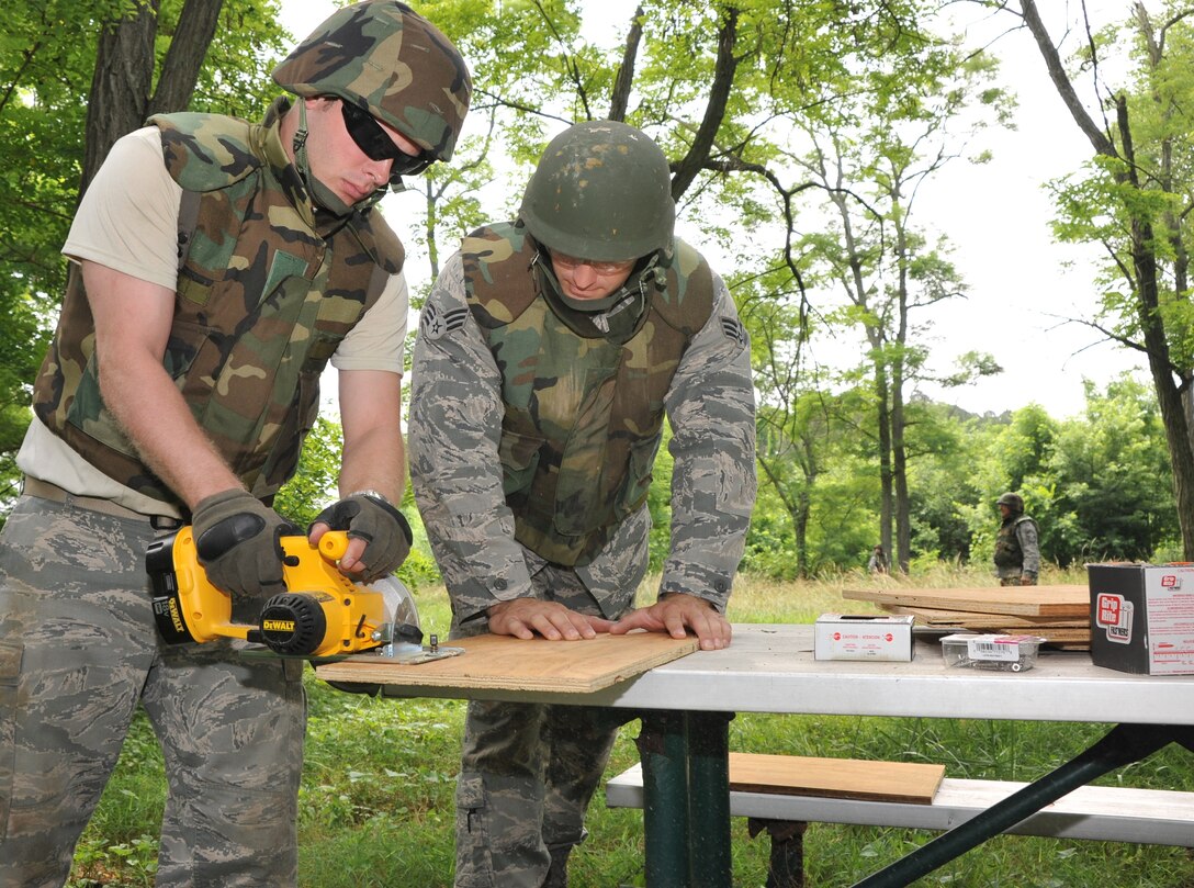 Two 932nd Civil Engineer Squadron members use plywood for a construction project after completing combat skills training on Scott Air Force Base, Ill.  Some 30 932nd CES members took part in convoy operations, tactics and air base defense at the June unit training assembly. (U.S. Air Force photo/Tech. Sgt. Chris  Parr)