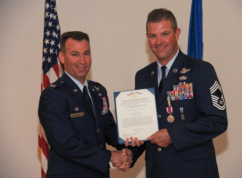 U.S. Air Force Chief Master Sgt. Michael Stone, 347th Rescue Group chief enlisted manager, receives his retirement certificate from Col. Chad Franks, 347th RQG commander, during a ceremony at Moody Air Force Base, Ga., June 30, 2011. Franks reflected on Stone’s career as an aerial gunner, instructor and mentor. (U.S. Air Force photo by Airman 1st Class Paul Francis/Released)