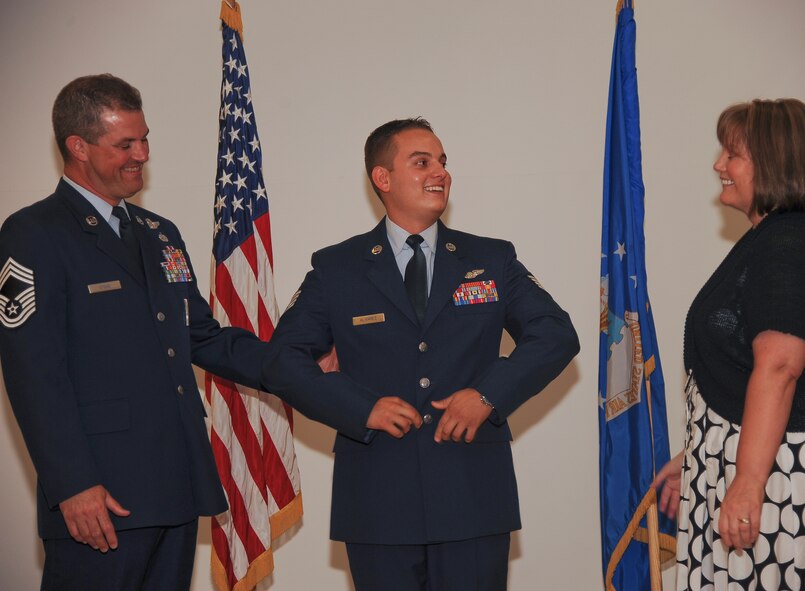 U.S. Air Force Staff Sgt. Alex Alvarez, 40th Airlift Squadron loadmaster, is congratulated by his mother Beverley Stone and father Chief Master Sgt. Michael Stone after being promoted during a retirement ceremony at Moody Air Force Base, Ga., June 30, 2011. Alvarez traveled from Dyess Air Force Base, Texas, to receive his promotion and honor his father’s retirement. (U.S. Air Force photo by Airman 1st Class Paul Francis/Released)