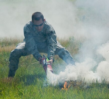 Senior Airman Benjamin McGovern, 436th Civil Engineer Squadron explosive ordnance disposal technician, extinguishes flames from a training explosion June 30, 2011, at Dover Air Force Base, Del. Team Dover’s EOD team learns the effective use of explosives at the range on base. (U.S. Air Force Photo/Airman 1st Class Jacob Morgan)