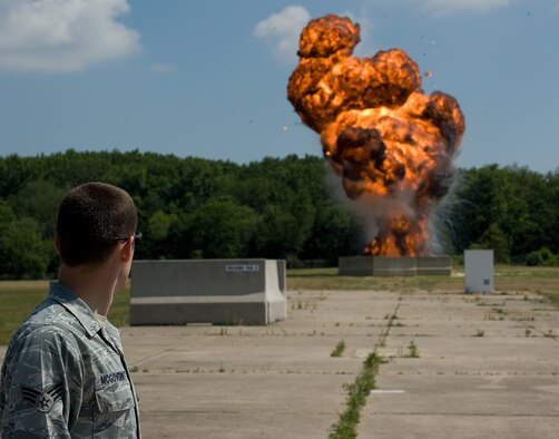 Senior Airman Benjamin McGovern, 436th Civil Engineer Squadron explosive ordnance disposal technician, watches as a training explosion detonates June 30, 2011, at Dover Air Force Base, Del. The training EOD technicians receive allows them to learn the nature of explosives to collect forensic evidence later if needed. (U.S. Air Force Photo/Airman 1st Class Jacob Morgan)