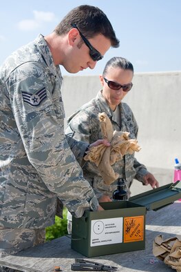 Staff Sgt. Clay Gorham (left) and Master Sgt. Jennifer Burch, 436th Civil Engineer Squadron explosive ordnance disposal technicians, prepare C-4 plastic explosive for a follow-up explosion June 30, 2011, at Dover Air Force Base, Del. C-4 is used to clear the range of harmful materials as well as unexploded ordnance. (U.S. Air Force Photo/Adrian Rowan)