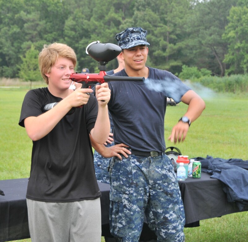 John Zilk fires a paintball gun while Seaman Anthony Gasbaro observes during Freedom Fest 2011 at Joint Base Charleston – Weapons Stations July 1. John is the son of senior chief petty officer John Zilk, and Gasbaro is a student at the Navy Nuclear Power Training Command. (U.S. Air Force photo/Airman Jared Trimarchi
