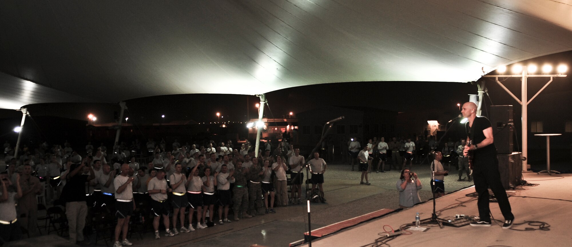 Deployed military members give a standing ovation as Vertical Horizon wraps up their final musical performance July 4, during an Independence Day celebration for the 379th Air Expeditionary Wing and its partner units. (U.S. Air Force photo/Senior Airman Paul Labbe)