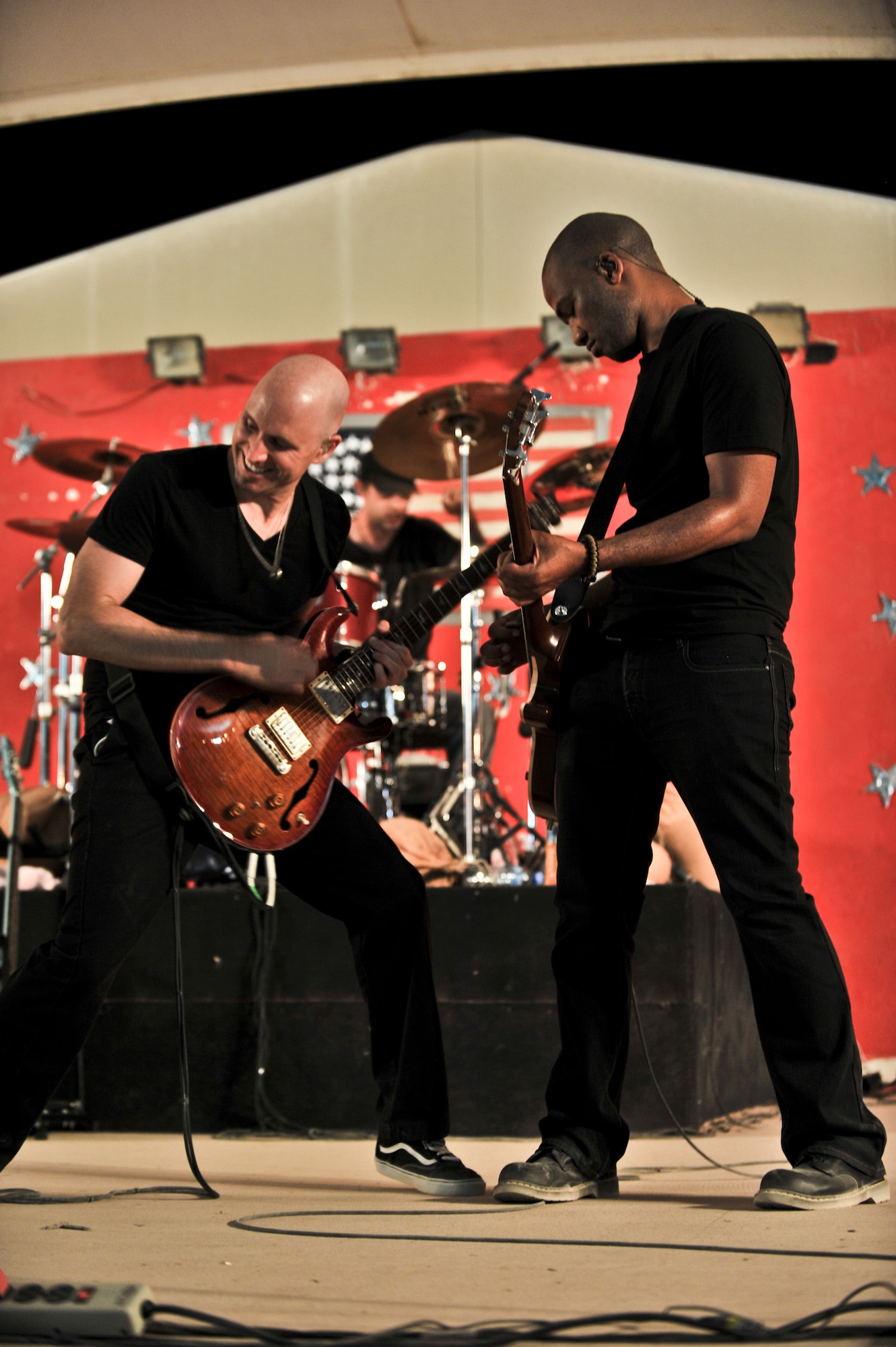 Vertical Horizon members, Matt Scannell and Cedric LeMoyne, jam together during an Independence Day celebration held for deployed military members from the 379th Air Expeditionary Wing and partner units in Southwest Asia, July 4. The band performed a two-night show to bolster the morale of those serving in the area of responsibility. (U.S. Air Force photo/Senior Airman Paul Labbe)