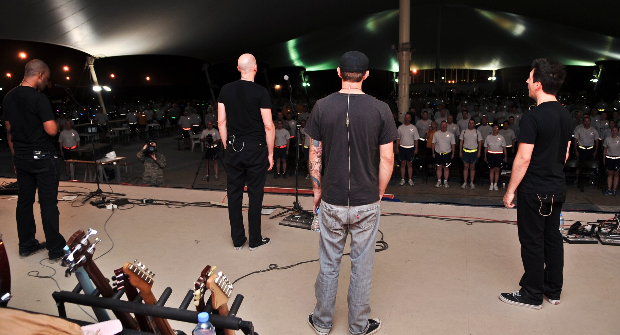 (From Left) Cedric LeMoyne, bassist; Matt Scannell, lead singer; Ronald LaVella, drummer; and Stephen Fekete , lead guitarist, lead deployed service members in singing the National Anthem at an Independence Day performance in Southwest Asia, July 4. They are members of Vertical Horizon, a multi-platinum selling band on its third overseas trip in support of the military members currently deployed to the area of responsibility. (U.S. Air Force photo/Senior Airman Paul Labbe)