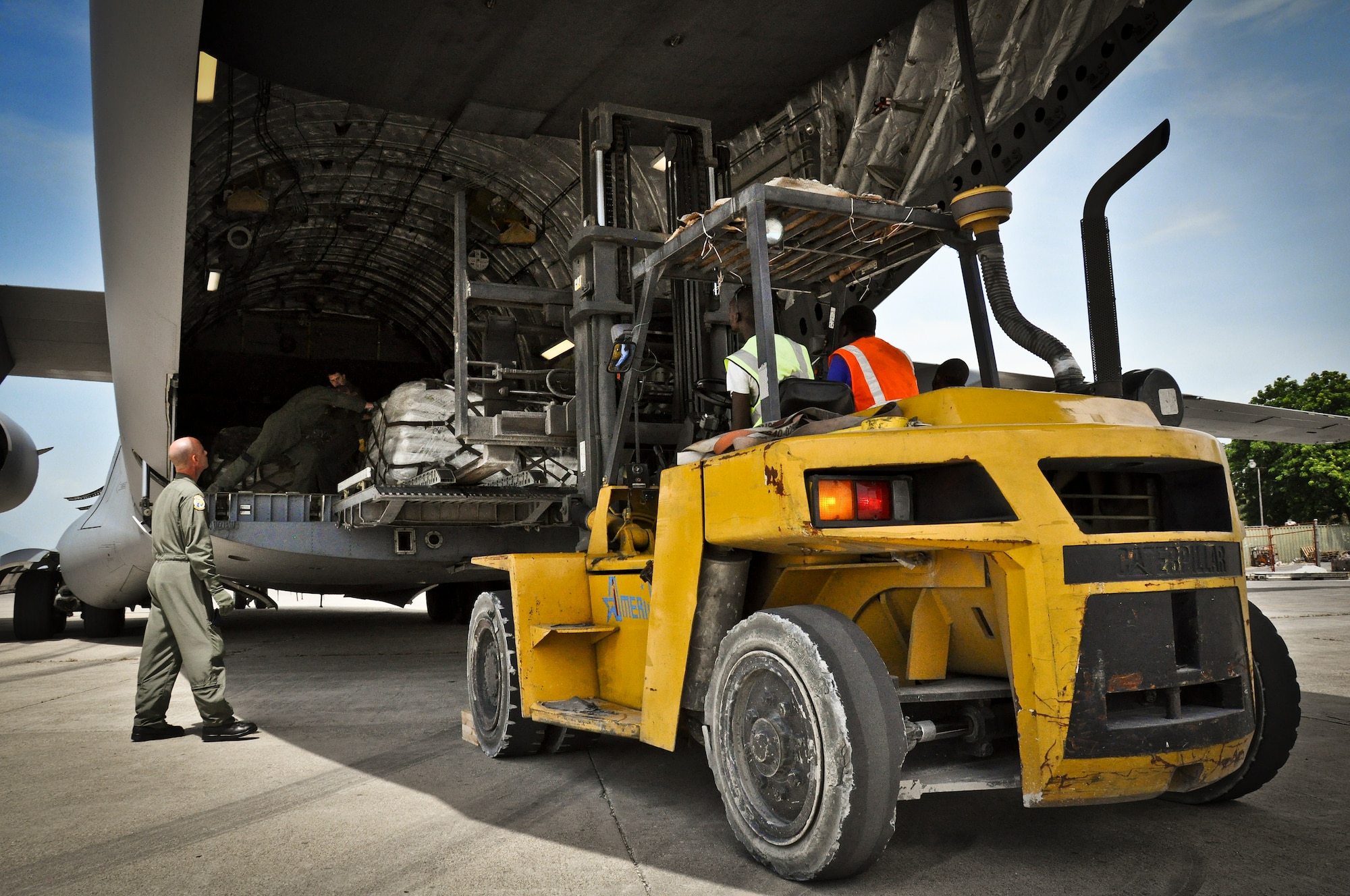 Technical Sergeant Arrin Baker of 300th Airlift Squadron checks the verticle clearance of a forklift during a humanitarian aid download in Haiti on July 1, 2011. (U.S. Air Force Photo/SSgt. Rashard Coaxum) 