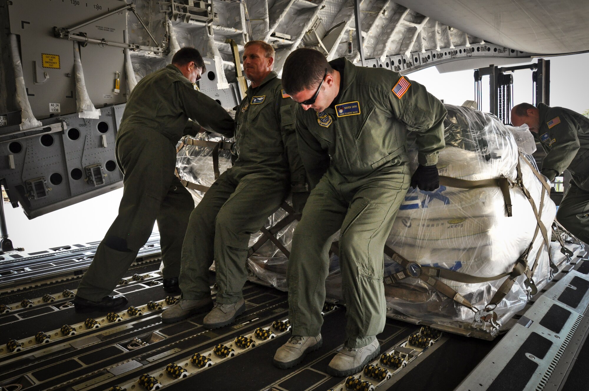 Loadmasters with the 300th Airlift Squadron help push a pallet of rice onto a forklift during a humanitarian aid mission to the island of Haiti on July 1, 2011. (U.S. Air Force Photo/SSgt. Rashard Coaxum) 
