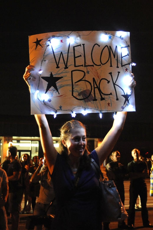 Casey Star holds a welcome home sign for her husband Capt. Thomas Star July 1 at Joint Base Charleston -  Air Base, S.C.  Captain Star  was one of more than 120 Airmen from the 17th Airlift Squadron returning home after a four-month deployment to the Middle East.  While deployed, the Airmen flew roughly 2, 850 sorties and airlifted more than 107 million pounds of cargo through out the area of responsibility.  (U.S. Air Force photo Staff Sgt. Nicole Mickle)