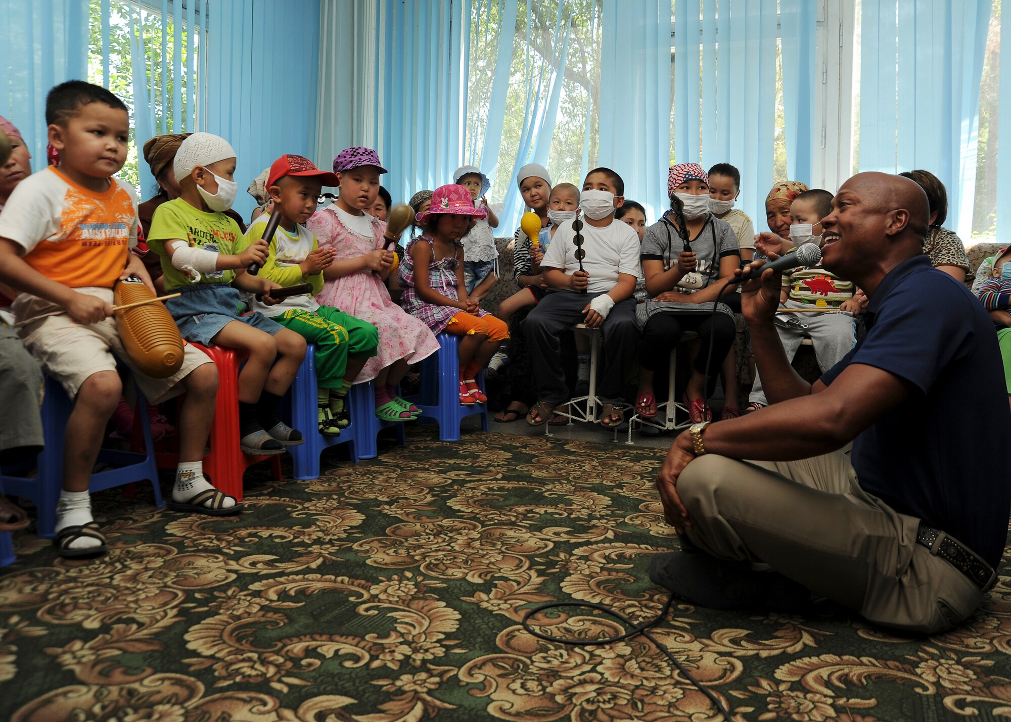 U.S. Air Force Tech Sgt. Lane McCray Jr., a vocalist with the Air Forces Central Expeditionary Band "Blue Hawk" from Naval Air Station Fort Worth Joint Reserve Base, Texas, sings with young children during a visit to a children's cancer center in Bishkek, Kyrgyzstan, July 4, 2011. The AFCENT Band builds troop morale and public diplomacy while touring the area of responsibility. (U.S. Air Force photo by Staff Sgt. Matthew Smith)

