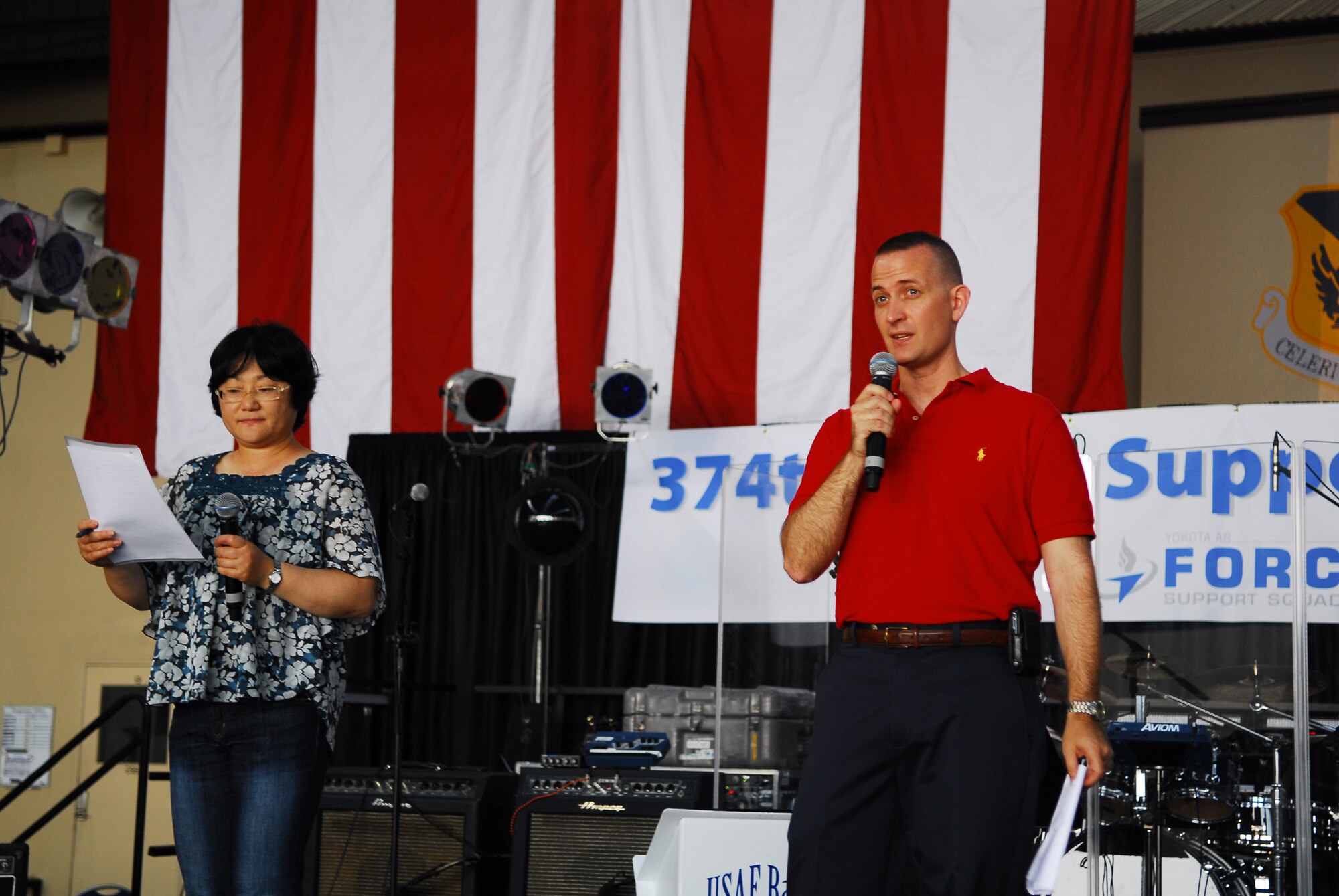 YOKOTA AIR BASE, Japan -- Col. Bill Knight (right), 374th Airlift Wing vice commander, speaks to the crowd during the Celebrate America event held July 2, 2011, at Yokota Air Base, Japan. Mitsuru Takahashi (left), chief of community relations for the 374th Airlift Wing public affairs office, translates the commander's speech for Japanese speaking patrons. (U.S. Air Force photo/Staff Sgt. Robin Stanchak)