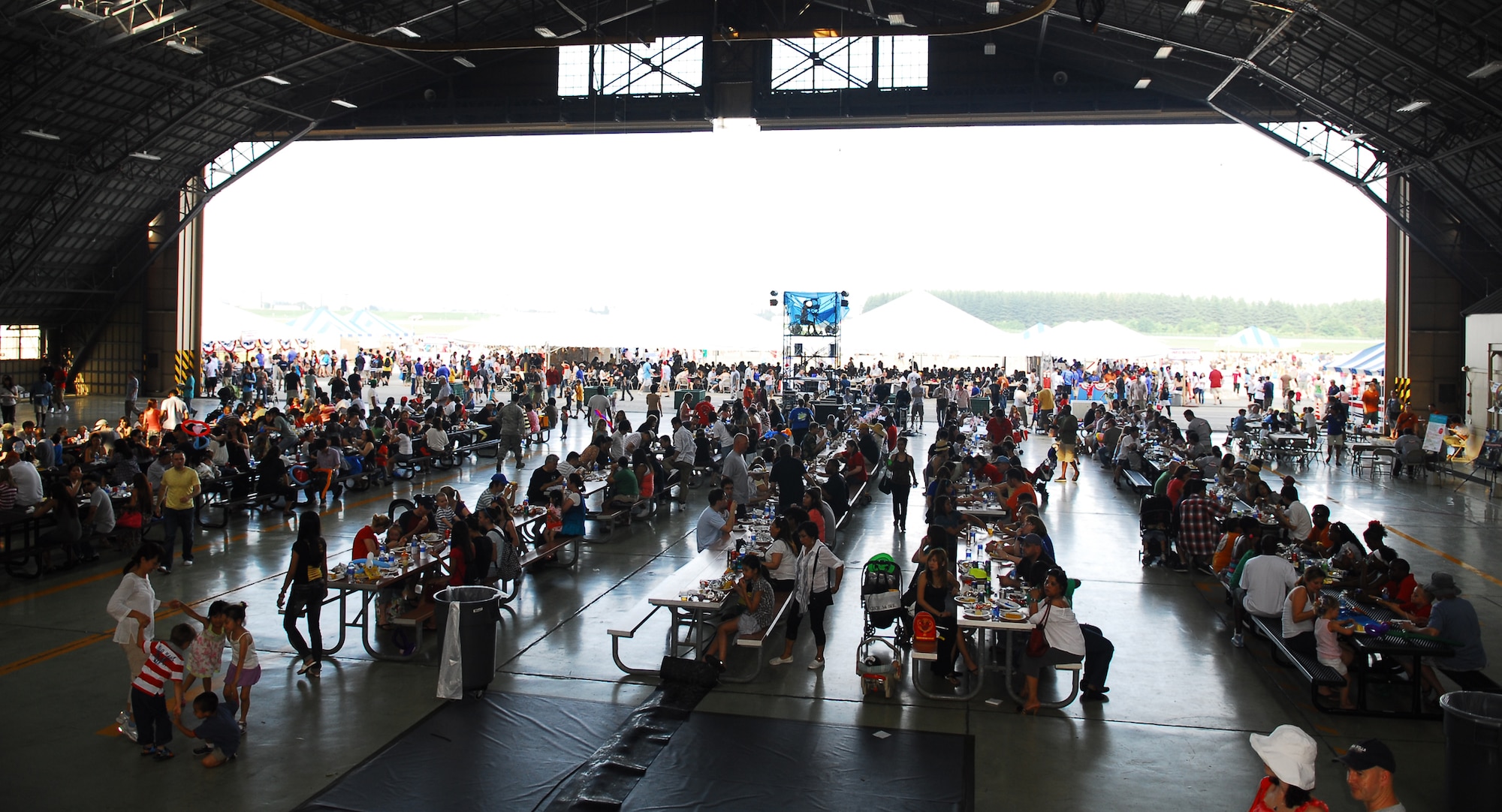 YOKOTA AIR BASE, Japan -- Attendees at the Celebrate America event held July 2, 2011, at Yokota Air Base, Japan, enjoy free food that was served during the event in Hangar 15. The festivities also included go-carts, carnival games, bouncy castles and a petting zoo. (U.S. Air Force photo/Staff Sgt. Robin Stanchak)