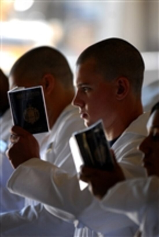 Plebes in the U.S. Naval Academy Class of 2015 stand at attention and begin memorizing portions of "Reef Points" while reporting to the school's campus on Induction Day (Minus One) in Annapolis, Md., on June 29, 2011.  The new 4th class midshipmen will be officially sworn in June 30, the beginning of Plebe Summer, six-weeks of training intended to transition the students from civilian to military life.  