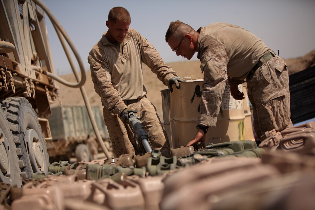 Corporal Nicholas Lavery (left) of Akron, Ohio, refuels dozens of fuel cans during a convoy mission. He and the two other fuel drivers with the logistics train, 3rd Battalion, 2nd Marine Regiment, have collectively supplied the unit with more than 250,000 gallons of fuel.