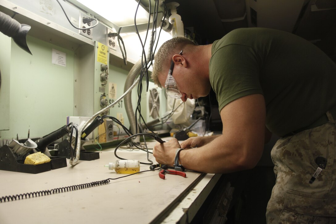 Sgt. George Thorpe, a native of Miami, repairs wires with a soldering tool  at Camp Bastion, Afghanistan, July 6. Thorpe is a micro miniature repair technician with Marine Aviation Logistics Squadron 40.