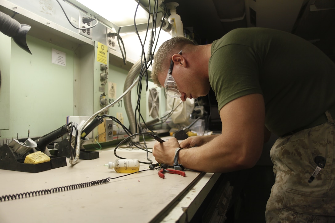 Sgt. George Thorpe, a native of Miami, repairs wires with a soldering tool  at Camp Bastion, Afghanistan, July 6. Thorpe is a micro miniature repair technician with Marine Aviation Logistics Squadron 40.