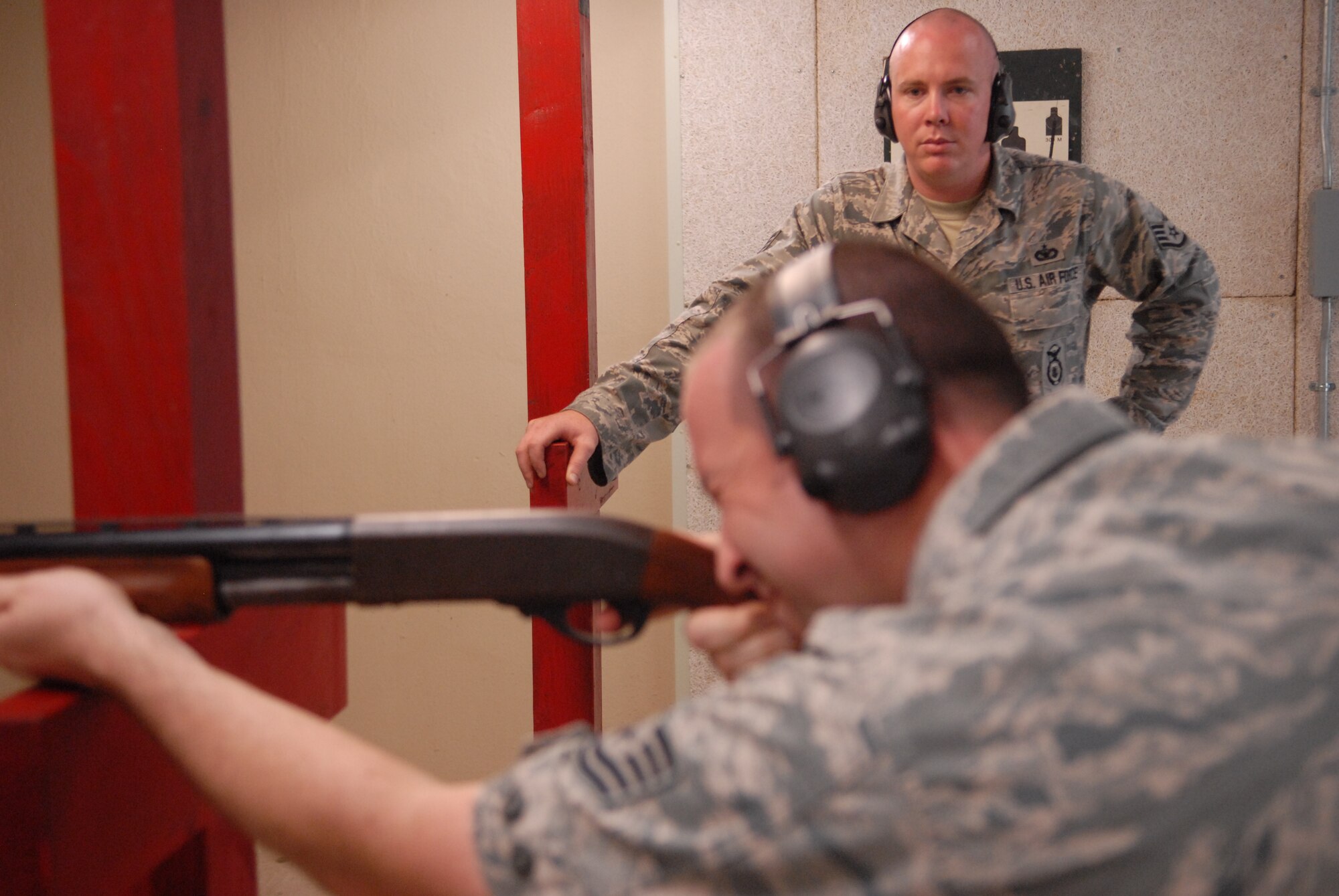 KUNSAN AIR BASE, Republic of Korea -- Staff Sgt. Scott Fitzgerald, 8th Security Forces Squadron combat arms instructor, oversees Tech. Sgt. Chad Calahan, 8th Fighter Wing flight safety NCO in charge, during a shotgun qualification course here July 6. Certified personnel use the shotgun for the Bird Aircraft Strike Hazard program, or BASH, to help reduce the number of birds on the airfield that may interfere with flight operations. (U.S. Air Force photo/Master Sgt. Sonny Cohrs)