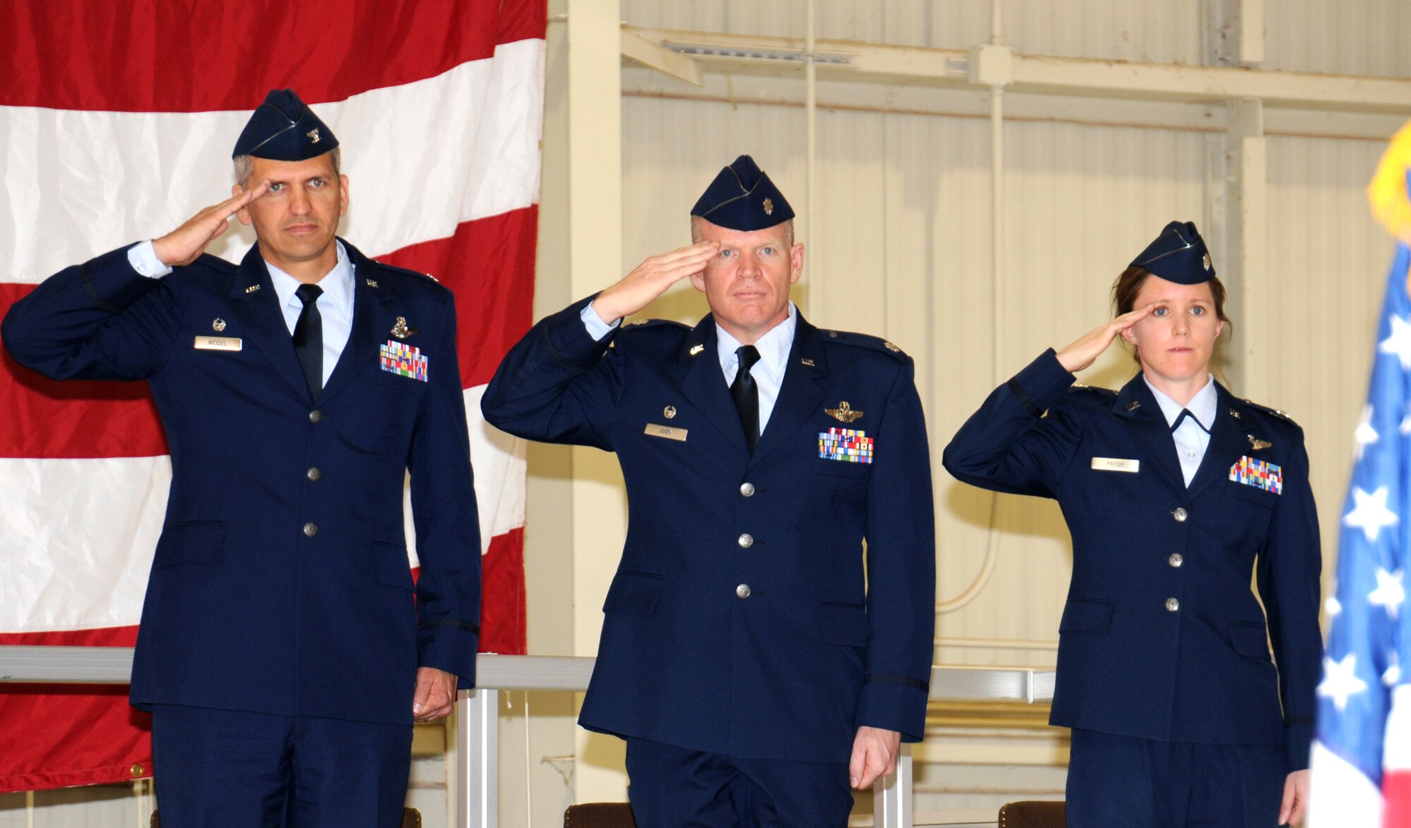 Col. Kurt Meidel, left, Lt. Col. Darrell Judy, center, and Lt. Col. Michelle Pryor, salute during the national anthem at the 32nd Flying Training Squadron change of command ceremony June 24, in Hangar 199, at Vance AFB, Okla. Meidel officiated the ceremony where Pryor assumed command from Judy, who will be reassigned to Stuttgart, Germany. Pryor served as director of operations with the 32nd FTS before taking command. (U.S. Air Force photo)