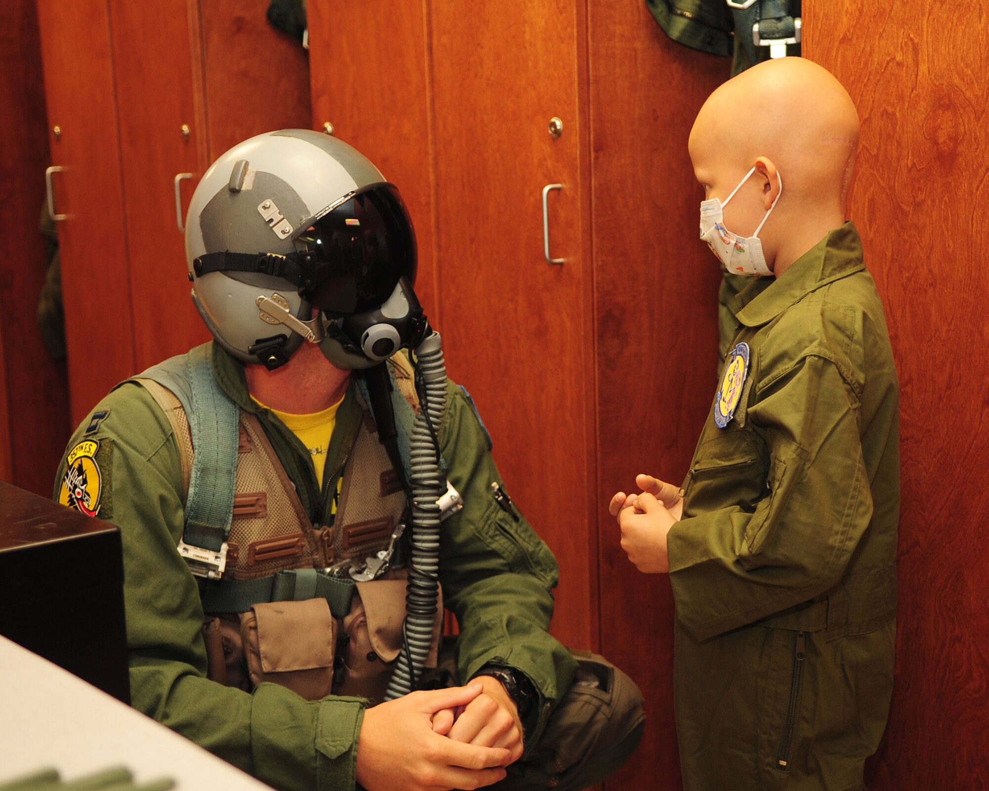 DAVIS-MONTHAN AIR FORCE BASE, Ariz. -Capt. Aaron Celusta, a pilot assigned to the 357th Fighter Squadron, explains the different functions of his helmet to Pilot for a Day participant Michael Castillo at the 355th Operations Group here June 24. (U.S. Air Force photo/Airman Jerilyn Quintanilla)