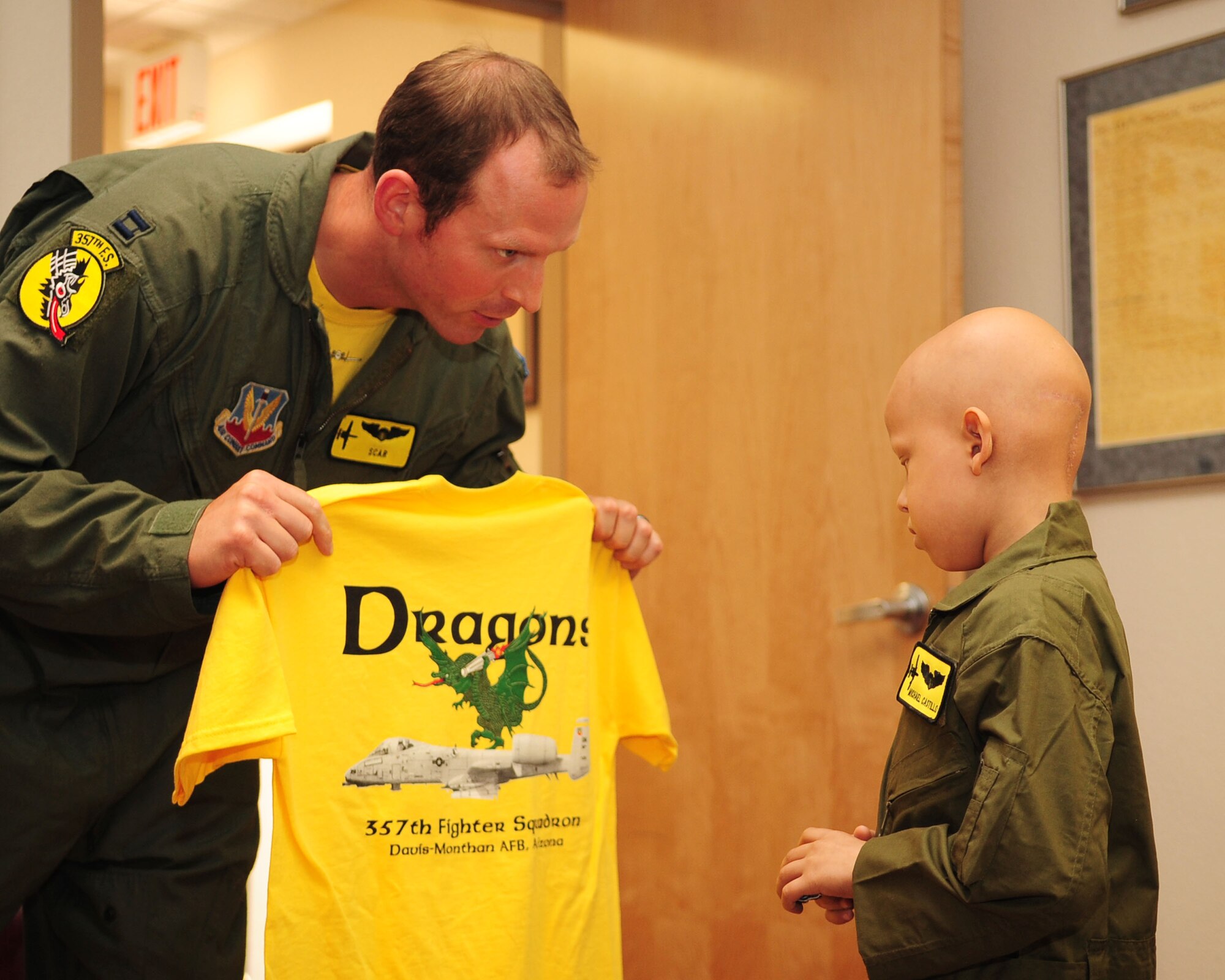 DAVIS-MONTHAN AIR FORCE BASE, Ariz. -Capt. Aaron Celusta, a pilot assigned to the 357th Fighter Squadron, presents Pilot for a Day participant, Michael Castillo, with a squadron t-shirt here June 24. As part of his tour, Michael and his family got to see parts of the base to include the 357th Fighter Squadron, the air traffic control tower, the D-M Fire Department and several aircraft static displays. (U.S. Air Force photo/Airman Jerilyn Quintanilla)