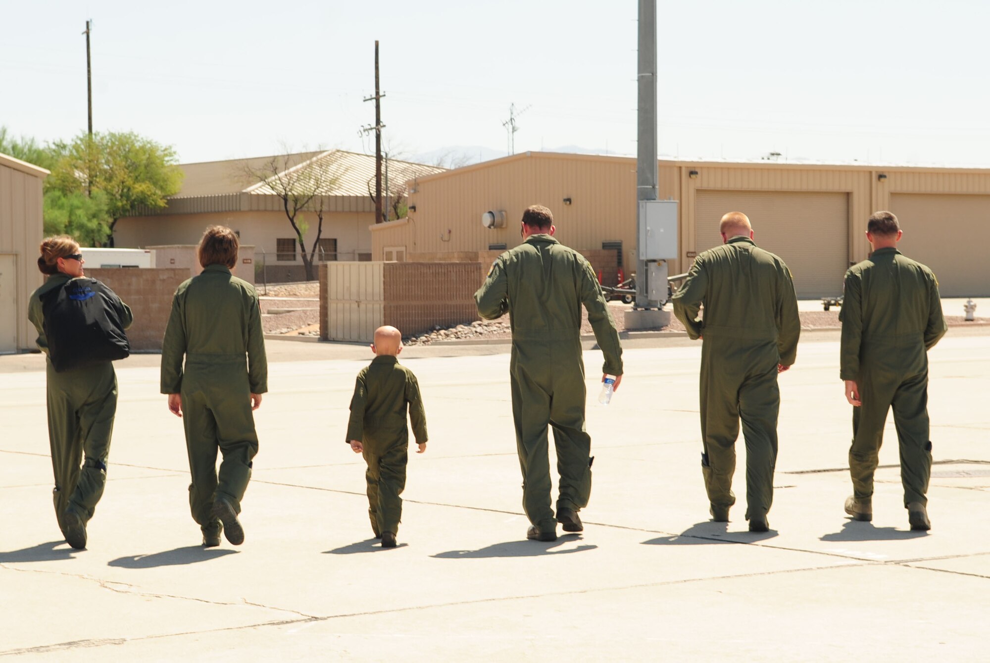 Pilot for a Day participant, Michael Castillo, walks off the flightline alongside a few flight crew members after touring a HC-130 static display here June 24. The Desert Lightning Team welcomed Michael and his family to the base where he got to tour several work centers to include the 357th Fighter Squadron, the Air Traffic Control tower and the 48th Rescue Squadron. (U.S. Air Force photo/Airman 1st Class Jerilyn Quintanilla)