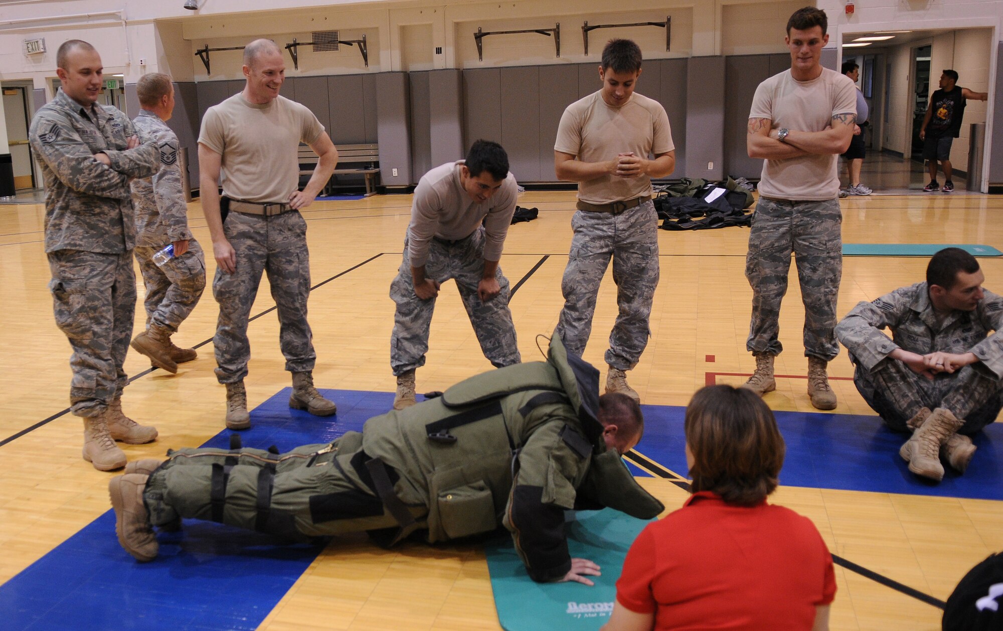 Explosive Ordnance Disposal Airmen encourage a wingman during the second annual First Sergeants' push-up a-thon June 28, 2011, Eielson Air Force Base, Alaska. EOD members wore an 80 lb. bomb suit, which is becoming a tradition at push-up a-thons. (U.S. Air Force photo/Airman 1st Class Janine Thibault)