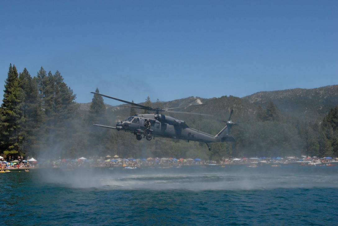 An HH-60G Pave Hawk helicopter from the California Air National Guard’s 129th Rescue Wing performs a low flyover above Lake Tahoe during a rescue simulation near Incline Beach, Nev. on July 3. Members from the 129th Rescue Wing, stationed at Moffett Federal Airfield, Calif., participated in Lake Tahoe’s fifth annual Red White and Tahoe Blue 4th of July celebration in Incline Village by providing a live aerial demonstration utilizing the wing’s MC-130P Combat Shadow fixed-wing four-engine aircraft, HH-60G Pave Hawk rescue helicopter and "Guardian Angel" pararescuemen. (Air National Guard photo by Senior Airman Jessica Green)