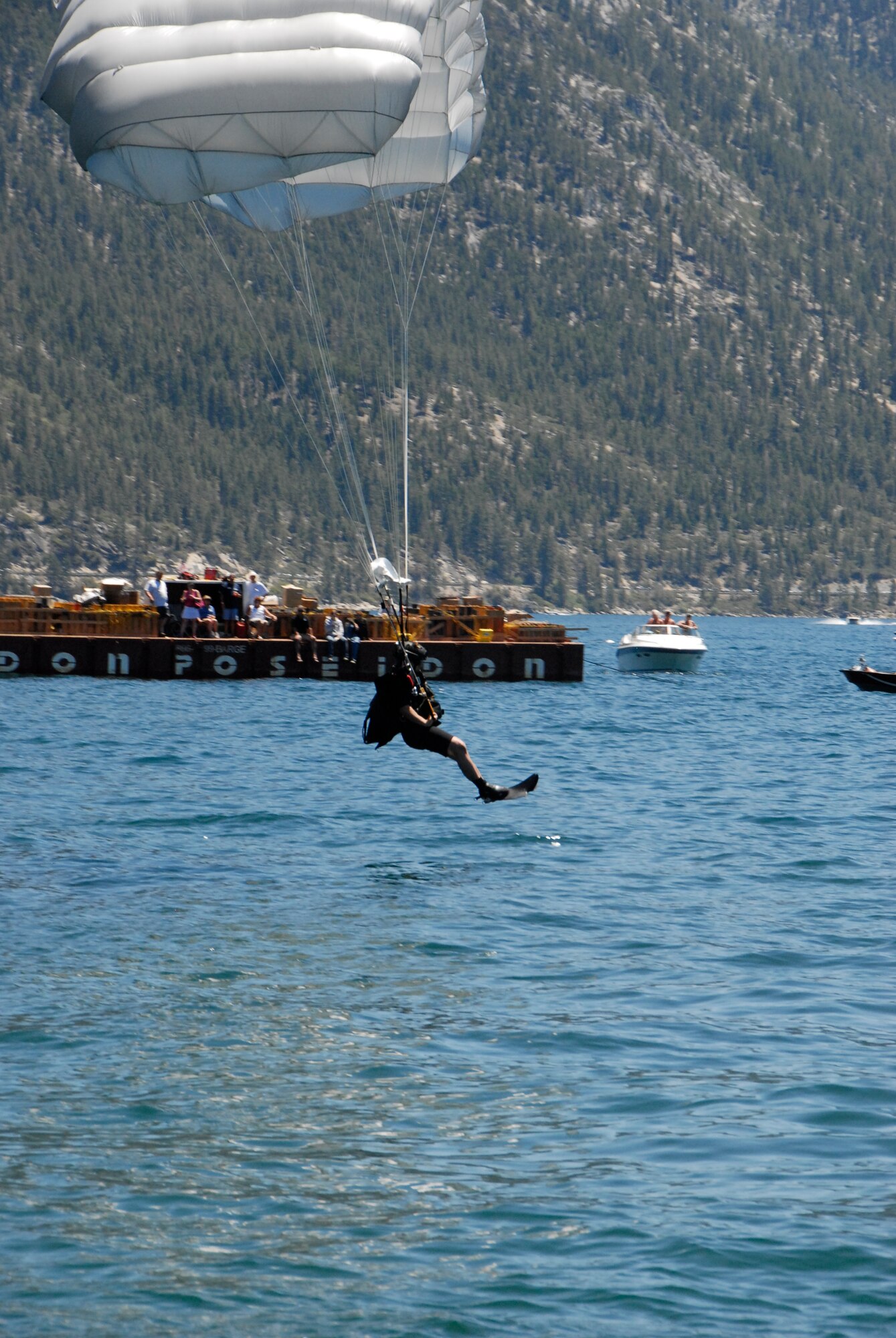 Staff Sgt. Mickey Chan, a pararescueman assigned to the California Air National Guard’s 131st Rescue Squadron, prepares to land in Lake Tahoe after parachuting from 5,000 feet out of an MC-130P Combat Shadow to perform a simulated rescue near Incline Village, Nev. on July. Members from the 129th Rescue Wing, stationed at Moffett Federal Airfield, Calif., participated in Lake Tahoe’s fifth annual Red White and Tahoe Blue 4th of July celebration in Incline Village by providing a live aerial demonstration utilizing the wing’s MC-130P Combat Shadow fixed-wing four-engine aircraft, HH-60G Pave Hawk rescue helicopter and "Guardian Angel" pararescuemen. (Air National Guard photo by Senior Airman Jessica Green)
