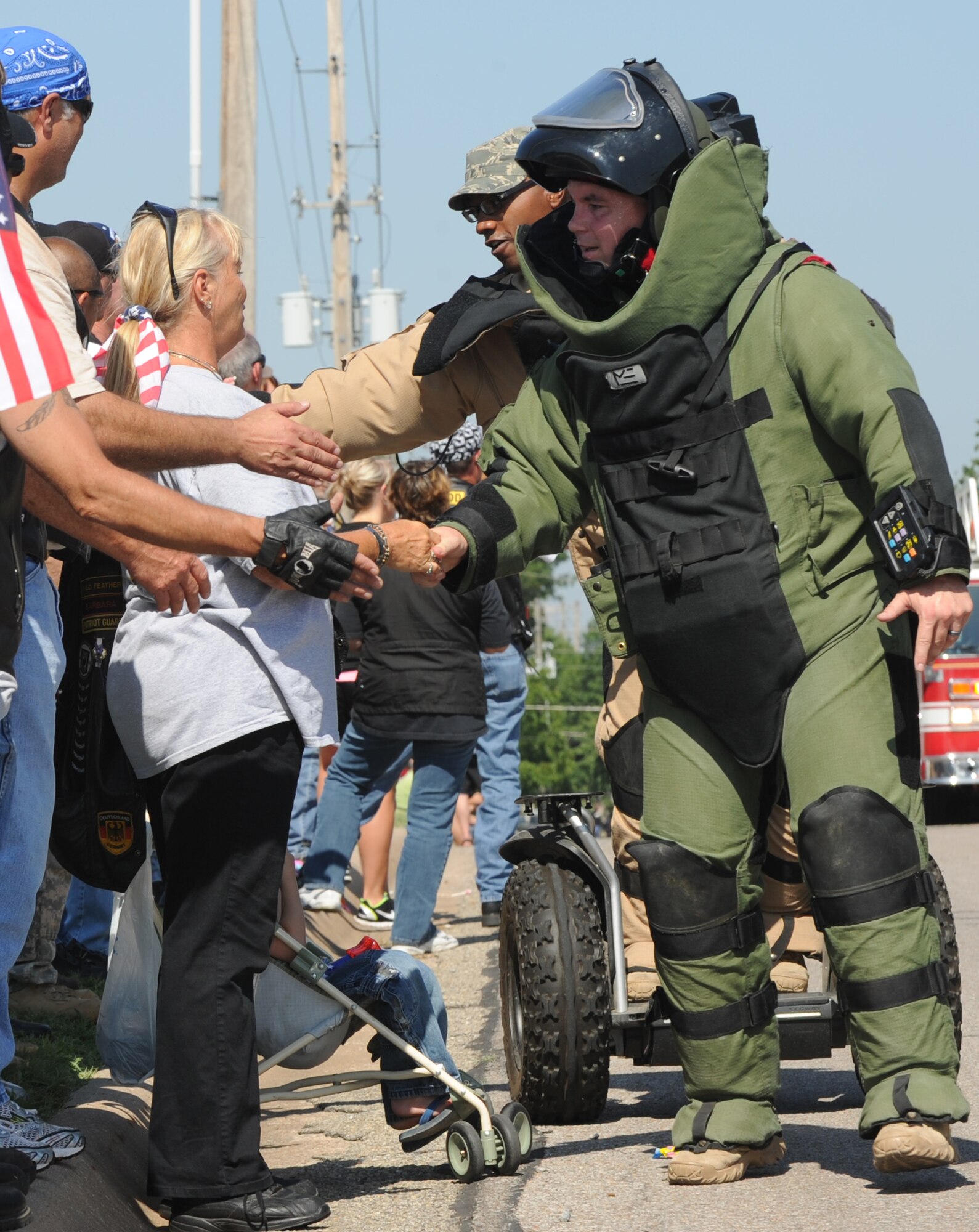 Two explosive ordnance disposal Airmen from the 22nd Civil Engineer Squadron shake local area resident’s hands July 4, 2011, Derby, Kan. The Airmen were part of nearly 200 Airmen that participated in the 2011 Derby Independence Day Parade. The parade, an annual event, was sponsored by the Veterans of Foreign Wars and the American Legion. (U.S. Air Force photo/Airman 1st Class Armando A. Schwier-Morales) 