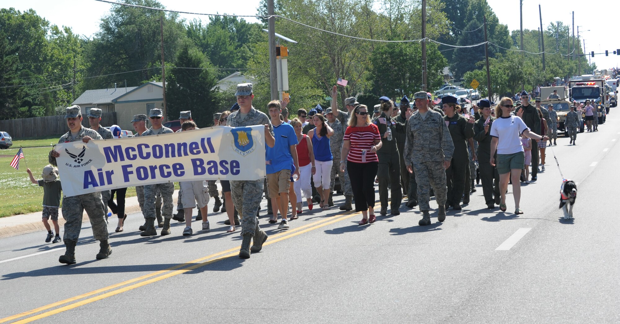 Team McConnell Airmen and their families walk down Madison Street in the 2011 Derby Independence Day parade July 4, 2011 Derby, Kan.  The annual parade is sponsored by the Derby Veterans of Foreign Wars and the American Legion.  Participants in the one-mile parade included community members, representatives from local military installations and veterans. (U.S. Air Force Photo/ Airman 1st Class Katrina M. Brisbin) 