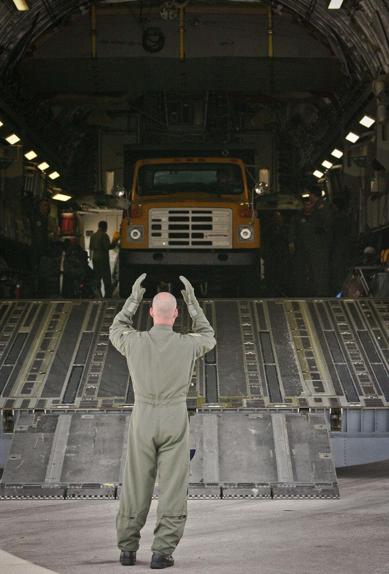 Tech. Sgt. Arrin Baker marshals a dump truck out of a C-17 Globemaster III July 1, 2011, during a humanitarian-aid off-load in Haiti. Baker is assigned to the 300th Airlift Squadron. (U.S. Air Force photo/Staff Sgt. Rashard Coaxum)
