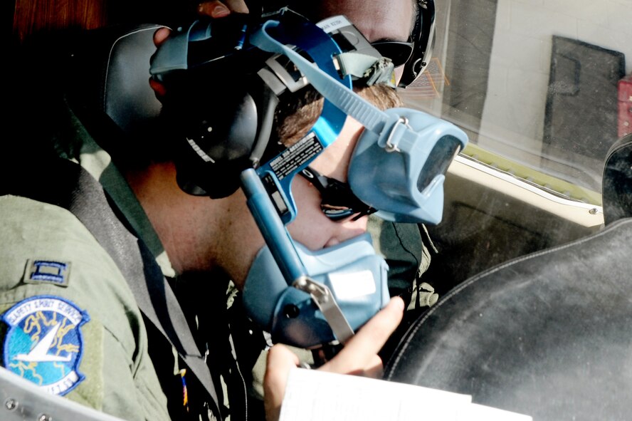 Capt. Shaun Hibshman, 76th Airlift Squadron, performs a pre-flight check of his oxygen mask prior to take-off during the first flight of the instructor pilot course at the C-21A formal training unit at Scott Air Force Base, Ill., on July 6, 2011. Captain Hibshman was the first to fly in the instructor pilot course under the 458th AS since it regained the C-21 training mission from the 45th AS at Kessler AFB, Miss. Captain Hibshman will return to the 76th AS at Ramstein Air Base upon graduation. (U.S. Air Force Photo/Staff Sgt. Brian J. Valencia)