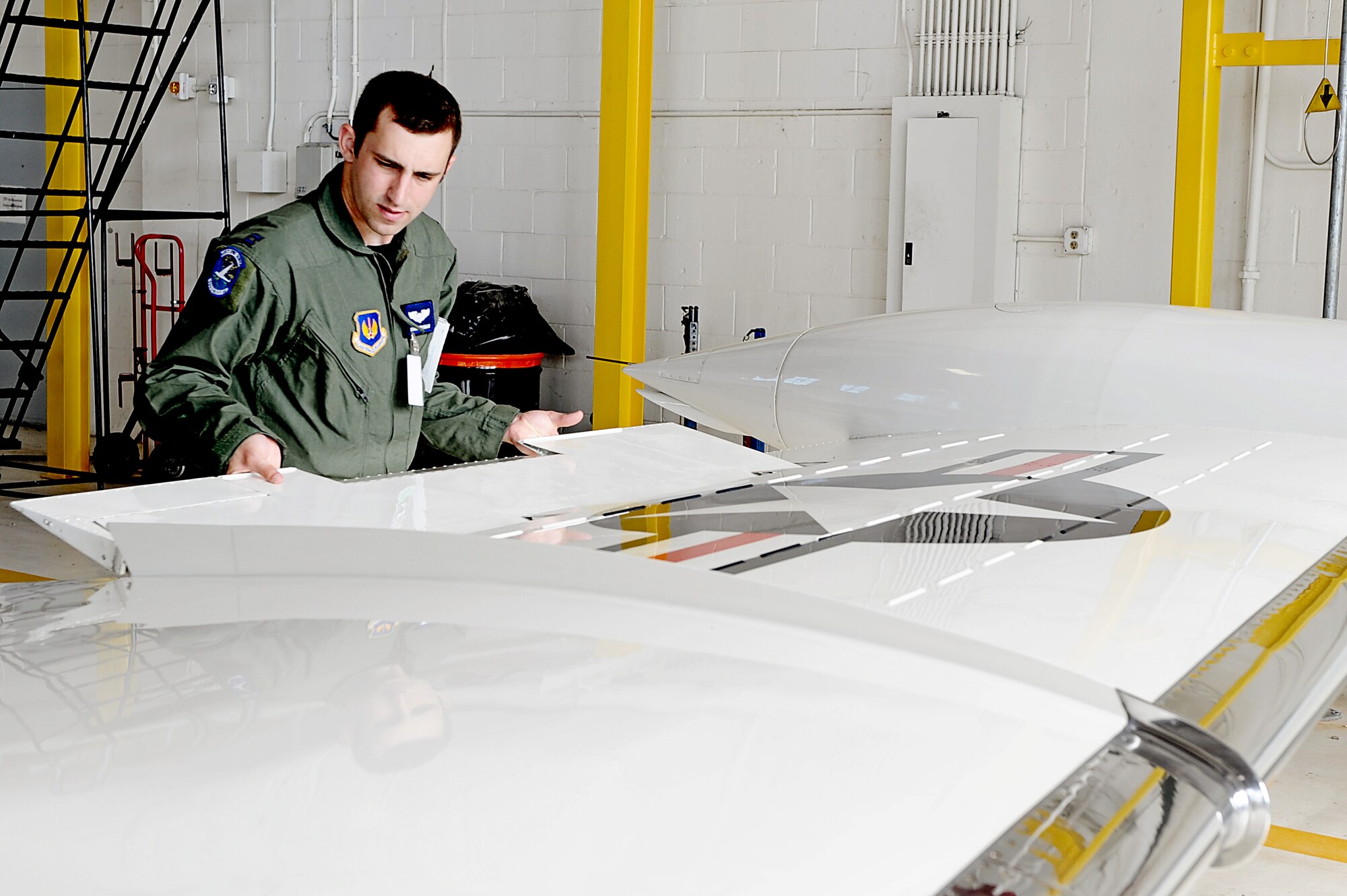 Capt. Shaun Hibshman, 76th Airlift Squadron, performs a pre-flight aircraft check prior to take-off during the first flight of the instructor pilot course at the C-21A formal training unit at Scott Air Force Base, Ill. July 6, 2011. Captain Hibshman was the first to fly in the instructor pilot course under the 458th AS since it regained the C-21 training mission from the 45th AS at Kessler AFB, Miss. Captain Hibshman will return to the 76th AS at Ramstein Air Base upon graduation. (U.S. Air Force Photo/Staff Sgt. Brian J. Valencia)