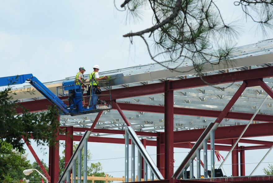 Contractors use a nail gun to hold metal support sheets in place at Moody Air Force Base, Ga., July 6, 2011.The future 93rd Air Ground Operations Wing and 23rd Mission Support Group headquarters building will be LEED-certified Silver. The LEED certification is awarded to buildings that are designed with high efficiency standards. (U.S. Air Force photo by Senior Airman Stephanie Mancha/Released)