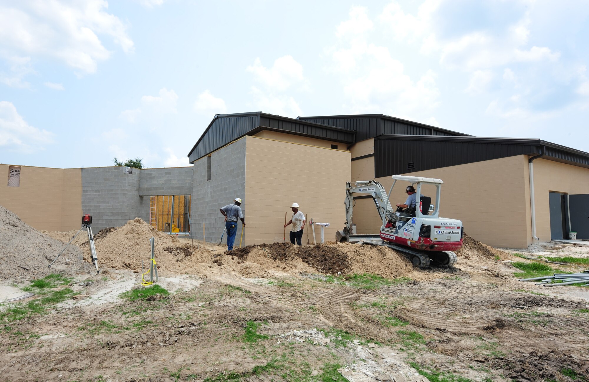 Contractors pack dirt before laying concrete outside the Hoffman Theater at Moody Air Force Base, Ga., July 6, 2011. The construction of the theater is part repair and part renovation costing $1.3 million. The construction is 45 percent complete and is scheduled to be finished by October. (U.S. Air Force photo by Senior Airman Stephanie Mancha/Released)