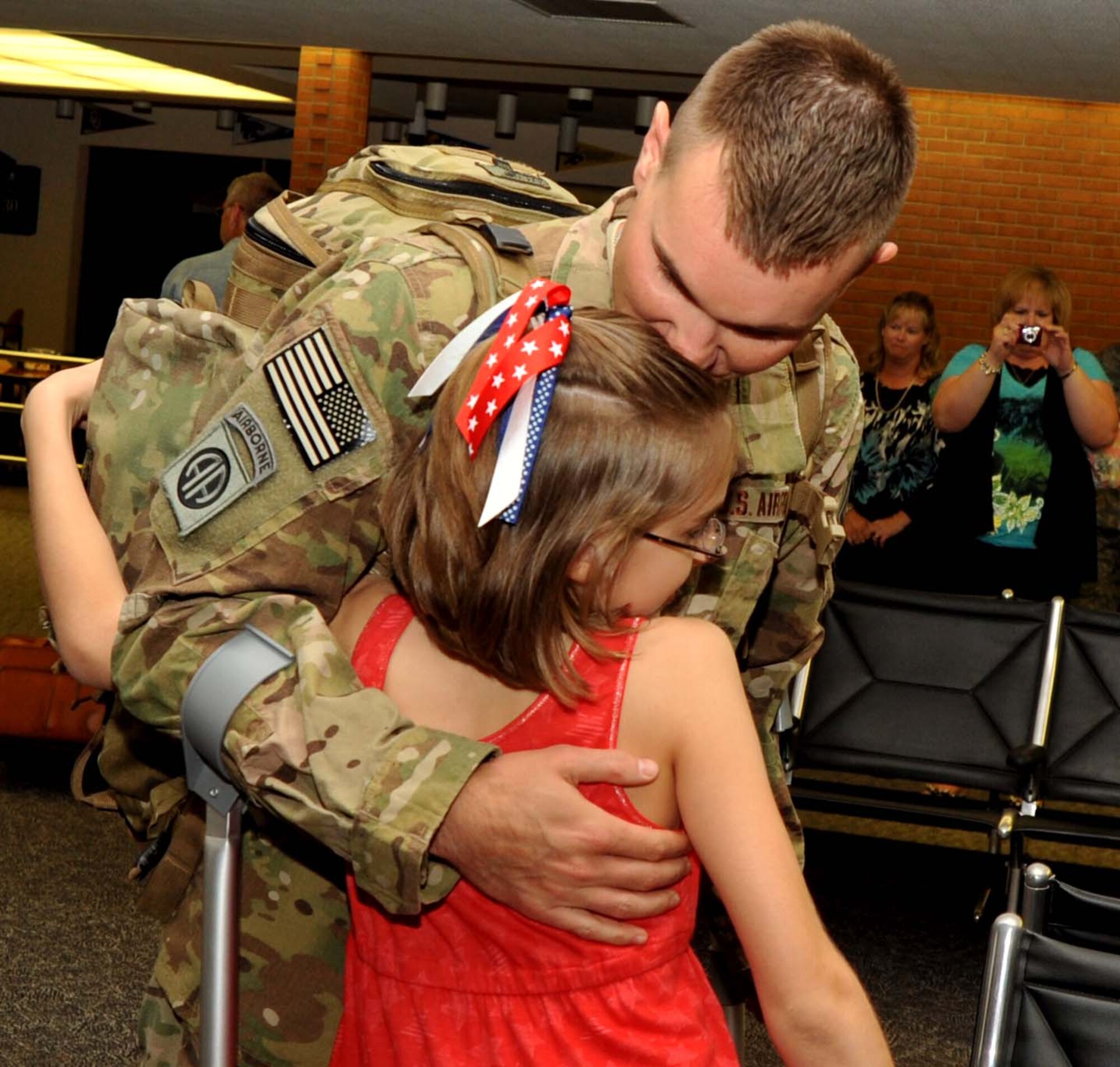 Staff Sgt. Beau Chastain, 22nd Civil Engineer Squadron Explosive Ordnance Disposal specialist, hugs his 11-year-old daughter, Emma, after returning home from Afghanistan. Chastain returned from a deployment early after sustaining a gunshot wound when his EOD unit was attacked in the Helmand Province.  (U.S. Air Force photo/ Senior Airman Abigail Klein)